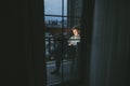 Concentrated freelancer sits in the evening on the apartment balcony working on a laptop, looking intently at the screen. Young Royalty Free Stock Photo
