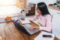 Concentrated freelancer woman making notes from internet working home sitting at table