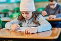 Concentrated on getting her schoolwork done. an elementary school girl doing school work in the classroom. Royalty Free Stock Photo