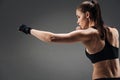 Concentrated girl boxing on a grey background Royalty Free Stock Photo