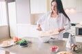 Concentrated girl is cooking breakfst. She is putting cheese into bowl. Girl looks concentrated and thoughtful. Royalty Free Stock Photo