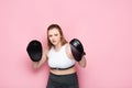 Concentrated overweight girl exercising with boxing