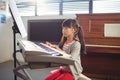 Concentrated girl looking at notes while practicing piano