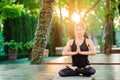 Concentrated girl sitting in lotus pose with hands in namaste and meditating or praying. Young woman with oriental Royalty Free Stock Photo