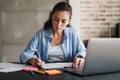 Concentrated girl using laptop computer while writing notes Royalty Free Stock Photo