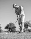 concentrated golfer in cap with golf club, golfing Royalty Free Stock Photo