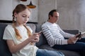 Concentrated granddaughter and grandfather playing digital games indoors Royalty Free Stock Photo