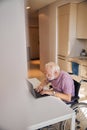 Disabled man in the wheelchair working on his computer