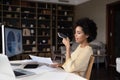 Concentrated happy young african american businesswoman recording audio message.