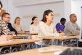 Concentrated hispanic girl at lecture during adult education class Royalty Free Stock Photo