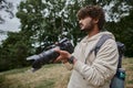 concentrated indian man holding digital camera