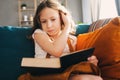 Concentrated kid girl reading interesting book at home Royalty Free Stock Photo