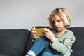 Concentrated kid playing video game on smartphone at home Royalty Free Stock Photo