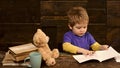 Concentrated kid writing in copybook. Preschool boy sitting at desk. Learning letters in kindergarten Royalty Free Stock Photo