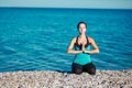 Concentrated lady meditates on beach. Sea and fresh air. Yoga and fitness concept. Healthy lifestyle idea, copy space