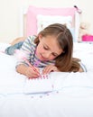 Concentrated Little girl writing on a notebook Royalty Free Stock Photo