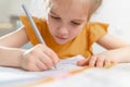 A concentrated little schoolgirl does her homework.