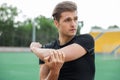 Concentrated male athlete make stretching exercises outdoors Royalty Free Stock Photo
