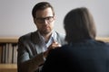 Concentrated male hr manager in glasses listening to job candidate.