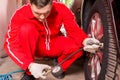 Concentrated male motor mechanic checking the air pressure of a Royalty Free Stock Photo