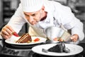 Concentrated male pastry chef decorating desserts Royalty Free Stock Photo