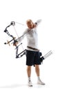 Concentrated man, archery athlete with special equipment training, aiming archery bow on target isolated over white Royalty Free Stock Photo