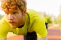 Concentrated man getting ready to run on sports track in park Royalty Free Stock Photo