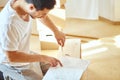 Concentrated man reading instructions to assemble furniture at home Royalty Free Stock Photo