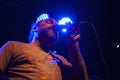 Concentrated man singing for audience uses microphone illuminated by blue light nightlife in Mexico city Royalty Free Stock Photo