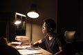 Concentrated man using computer for studying and writing in notepad Royalty Free Stock Photo