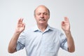 Concentrated mature man in white shirt tries to relax after hard working day, daydreams, keeps fingers together. Royalty Free Stock Photo