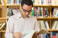 Concentrated mature student reading book in library Royalty Free Stock Photo