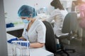 Focused biochemist in sterile latex gloves and a face mask