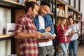 Concentrated men students standing in library reading book. Royalty Free Stock Photo