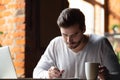 Focused male student make notes studying in cafe