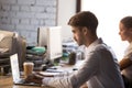 Focused male employee busy working at laptop in coworking office