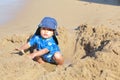 Mixed little toddler boy playing in sand on beach by sea Royalty Free Stock Photo