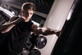 Concentrated muscular kickbox fighter exercising with punch bag on white in gym Royalty Free Stock Photo