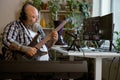 Concentrated musician plays bas guitar recording song in home studio Royalty Free Stock Photo