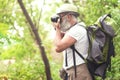 Concentrated old male tourist photographing forest Royalty Free Stock Photo