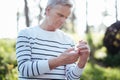 Concentrated pensioner holding bottle with pills outdoors Royalty Free Stock Photo