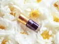 Concentrated perfume in a mini bottle on a floral background. Royalty Free Stock Photo