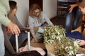 Concentrated, positive female students sitting on the floor pack carton boxes, prepare to move to new university campus Royalty Free Stock Photo