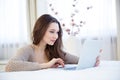 Concentrated pretty woman using laptop at home