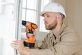 concentrated professional builder drilling hole in door Royalty Free Stock Photo