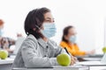 concentrated schoolboy in medical mask writing