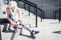 Concentrated senior lady going to begin exercise on city ladder Royalty Free Stock Photo