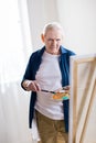 Concentrated senior man drawing picture in art workshop