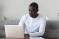 Concentrated serious millennial african american guy working with laptop. Royalty Free Stock Photo