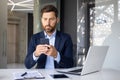 Concentrated and serious young businessman working in the office on a laptop, sitting at the table and typing a message Royalty Free Stock Photo